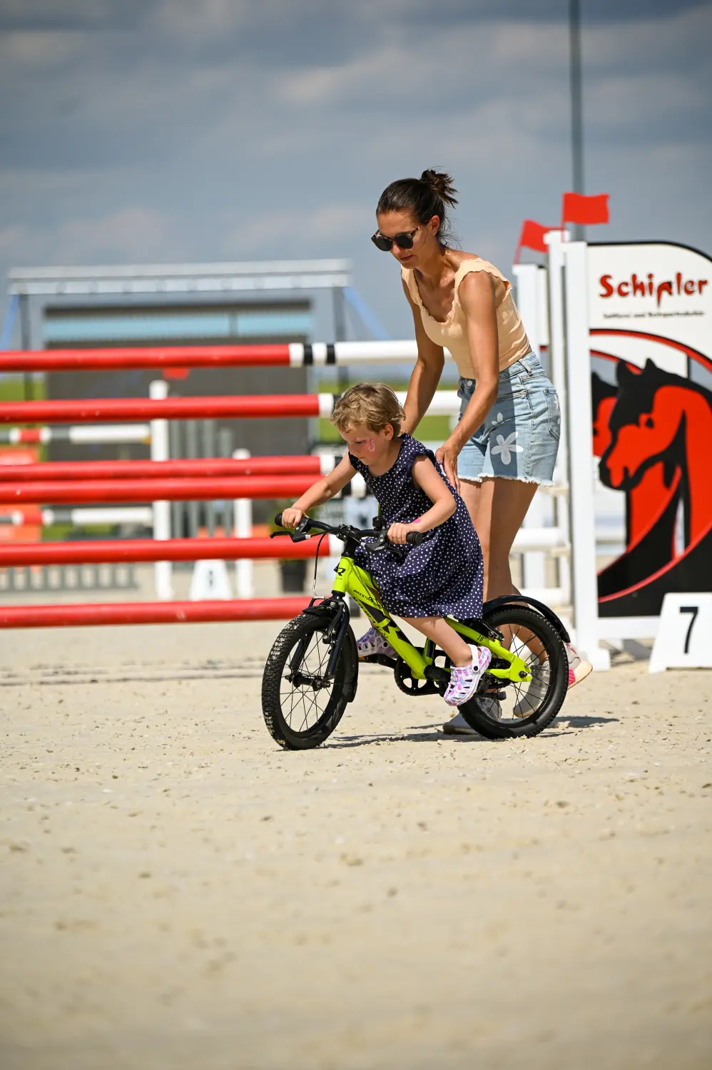 LRV Timmenrode e.V., Pferdeveranstaltungen, Kinderland, Eine Frau hilft ihrem Kind beim Radfahren